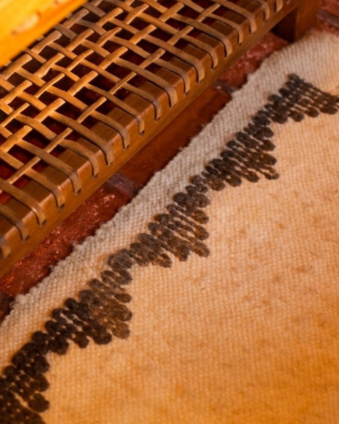 Detalhe de cadeira trançada e tapete artesanal