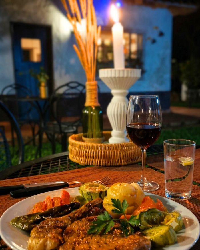 Detalhe do jantar com taça de vinho à luz de velas