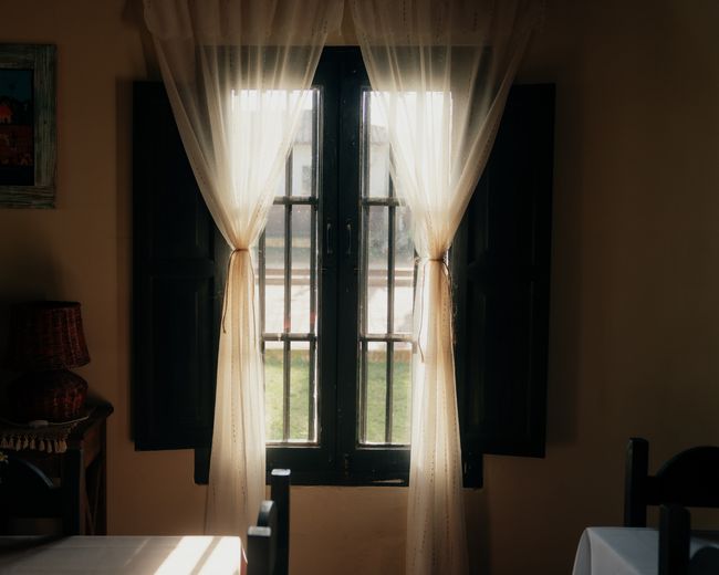 Janela com cortinas no salão de refeições