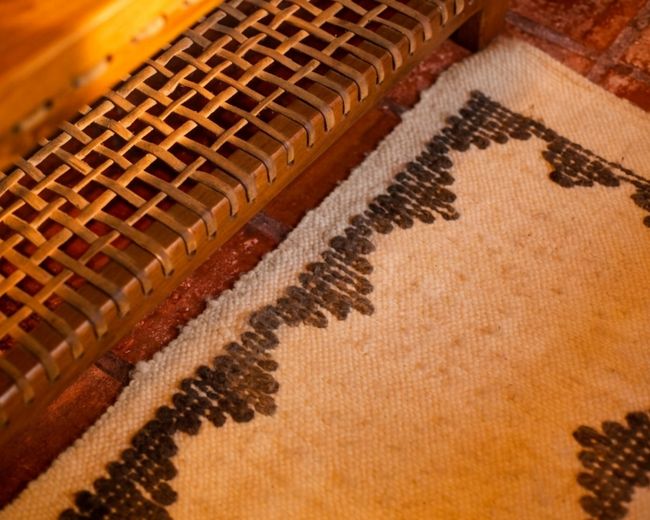 Detalhe de cadeira artesanal e tapete